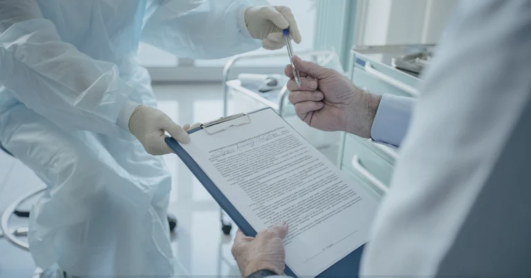A pharmacist hands a clipboard to an individual