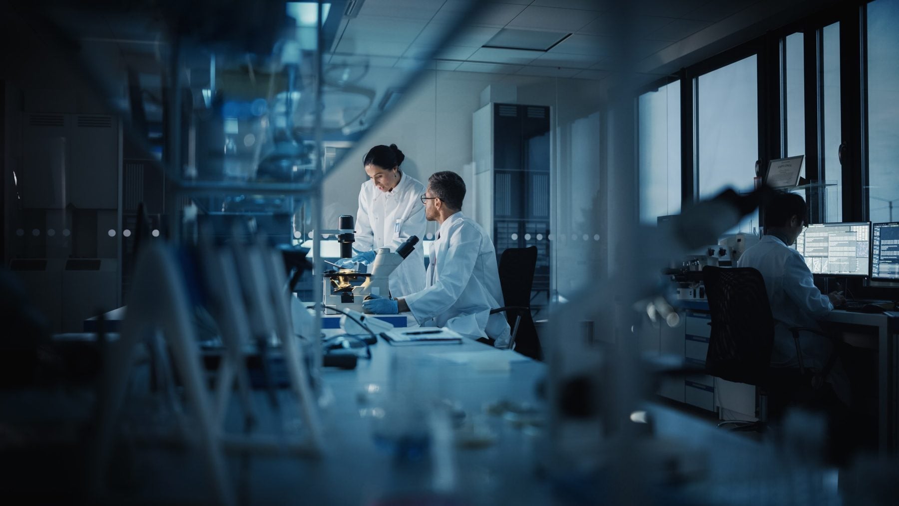 Laboratory scientists reviewing results at a microscope