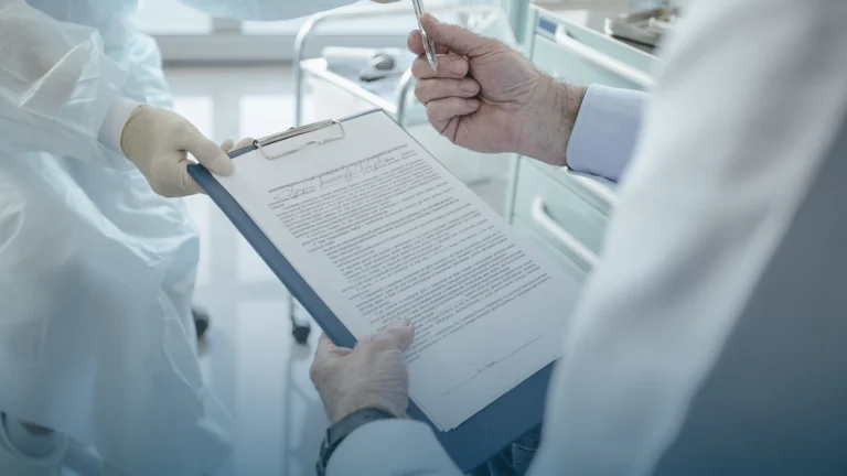 Two clinicians reviewing a signed document on a clipboard
