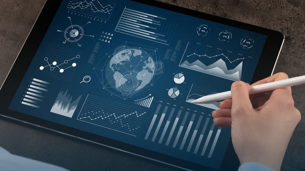 Hand with a stylus reviewing global analytics dashboards on a tablet