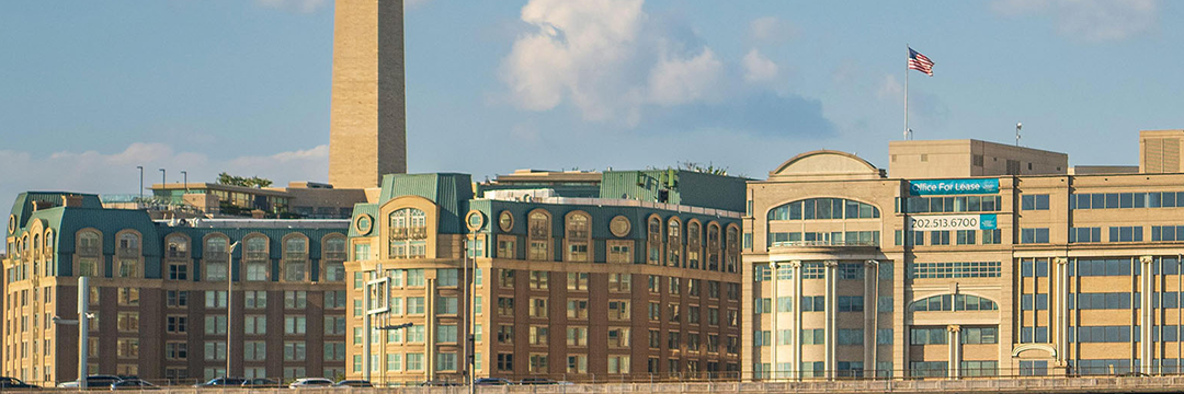 Washington Monument rising behind office buildings in Washington, D.C.