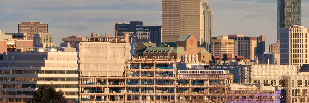 Office towers rising over a Massachusetts city in late afternoon light